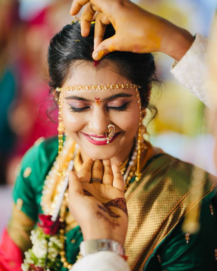 Bride glowing as haldi is applied during wedding rituals, natural makeup by Sonali Sarode, Nashik